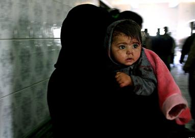 Иракская женщина в Бакубе бежит с раненым ребенком в больницу после нападения боевиков
