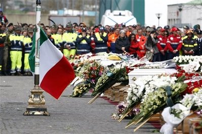An Italian flag waves next to a row of coffins during the funerals ...