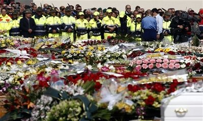 Coffins adorned with flowers are lined up during the funerals ...