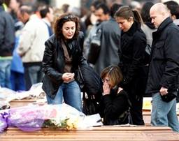 People react as they stand between coffins, prior to the funerals ...