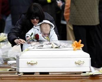 A woman and her son leave a rose during the state funeral ceremony ...