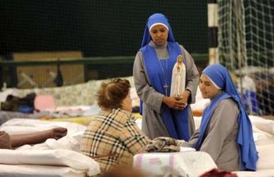 Nuns speak with an earthquake survivor in a camp for people ...