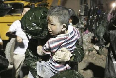 A boy is rescued from the debris of a collapsed building after ...