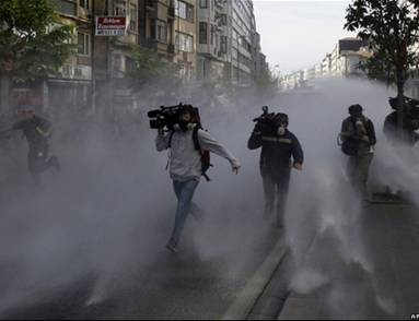 Телеоператоры бегут от водометов, которые полиция применила во время столкновений с демонстрантами в Стамбуле